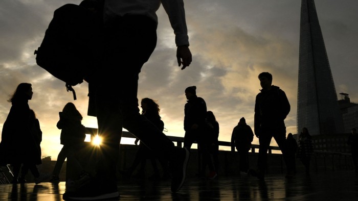 Commuters on their way to work cross London Bridge