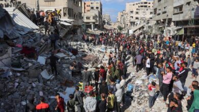 People gather around the rubble of a house destroyed in an Israeli strike as rescuers search for casualties on al-Jalaa street in central Gaza City