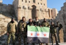 Rebel fighters pose for a photo in front of Aleppo’s citadel