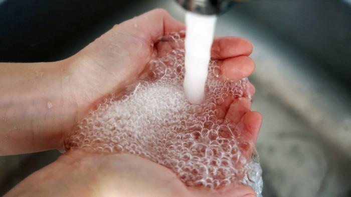 Water flows from a tap into cupped hands